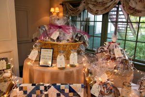 multiple raffle gift baskets surrounded by mason jars for tickets
