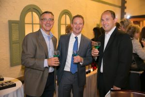 group of three men cheersing their blue green drinks