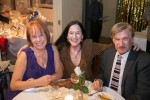 three guests smiling at a table