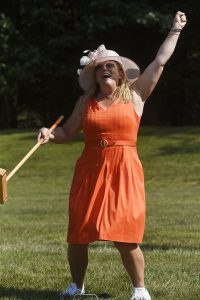 woman in orange exuberant with her croquet skills