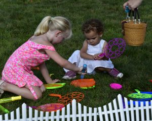 two young girls mess around with bubble wands at 4th annual croquet on the green