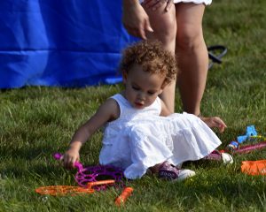 baby girl in white dress sitting on yard