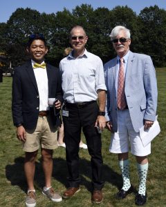 group of three in wacky outfits smiling on the croquet field