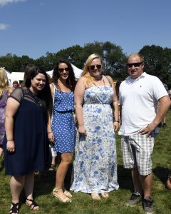 group of women in summer dresses smile with man in polo