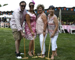 group showing off their yellow and orange mallets at 4th annual croquet on the green