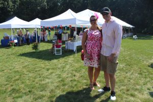 woman with fuzzy hat smiles with man in sunglasses at 4th annual croquet on the green