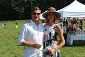 two event goers smile for the camera on a beautiful day at 4th annual croquet on the green
