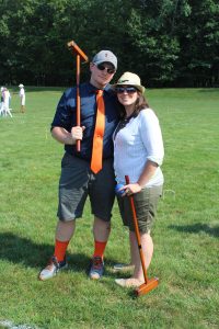 man and woman stand confidently daring someone to beat them in croquet