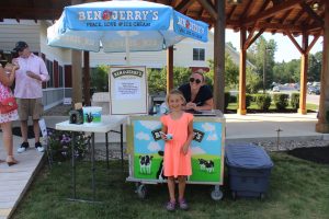 little girl proudly displaying her ice cream in front of ben and jerrys cart
