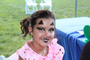 little girl shows off her cat face paint