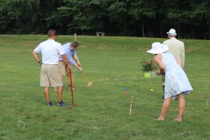 group playing watching man swing at 4th annual croquet on the green