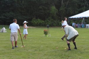 man in fedora takes a swing at his ball