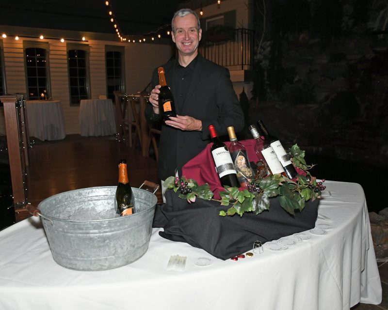 Bill Blake presenting a bottle of wine at the Vin Le Soir event