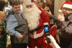 Man posing with Santa for a picture at the Holiday Tea event