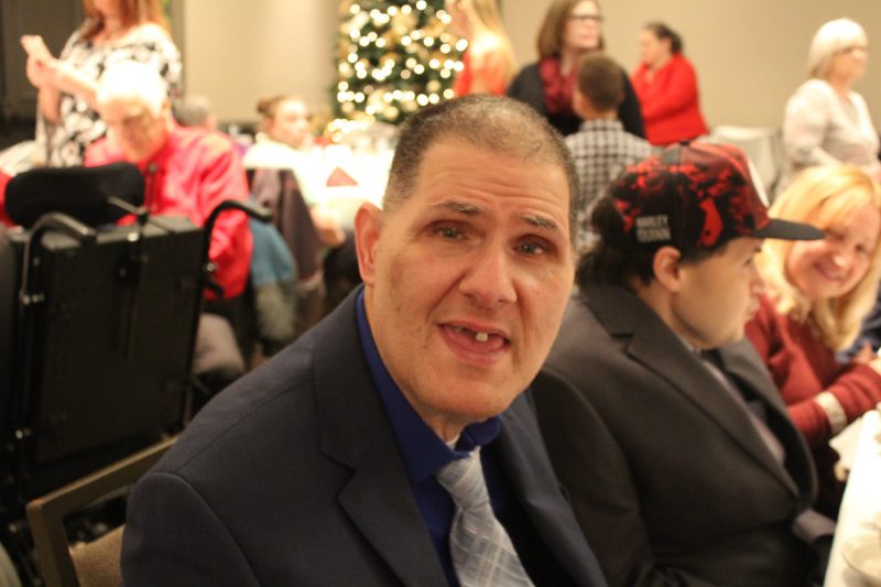 Man in suit smiling at the Holiday Tea event