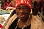 Woman smiling with Christmas hat on at the Holiday Tea event