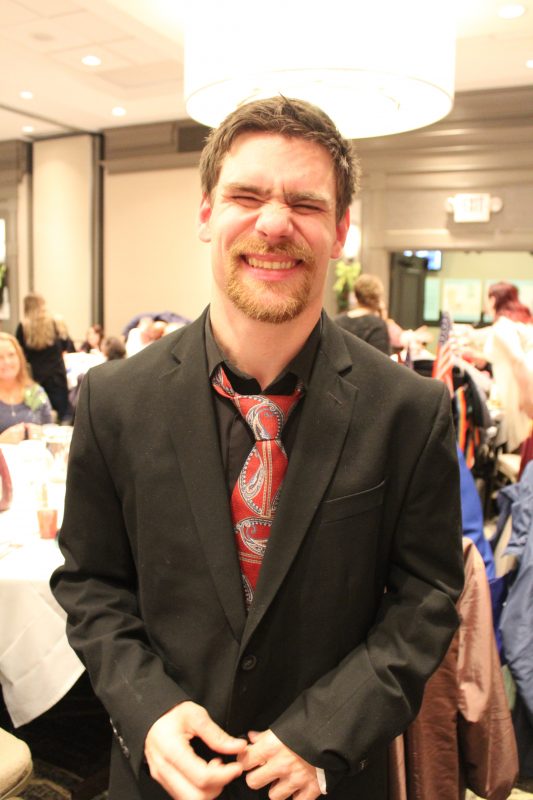 Man in suit smiling at the Holiday Tea party