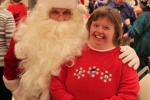 Woman smiling with Santa at the Holiday Tea party
