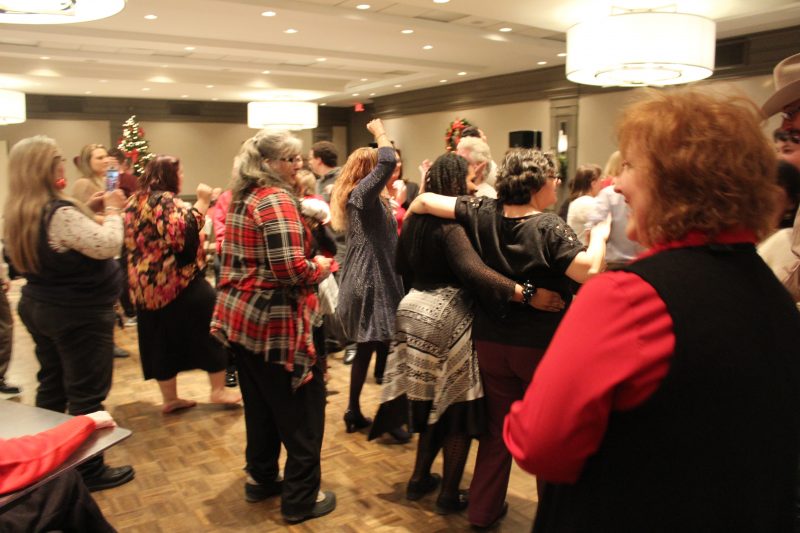 Group of people dancing at the Holiday Tea event