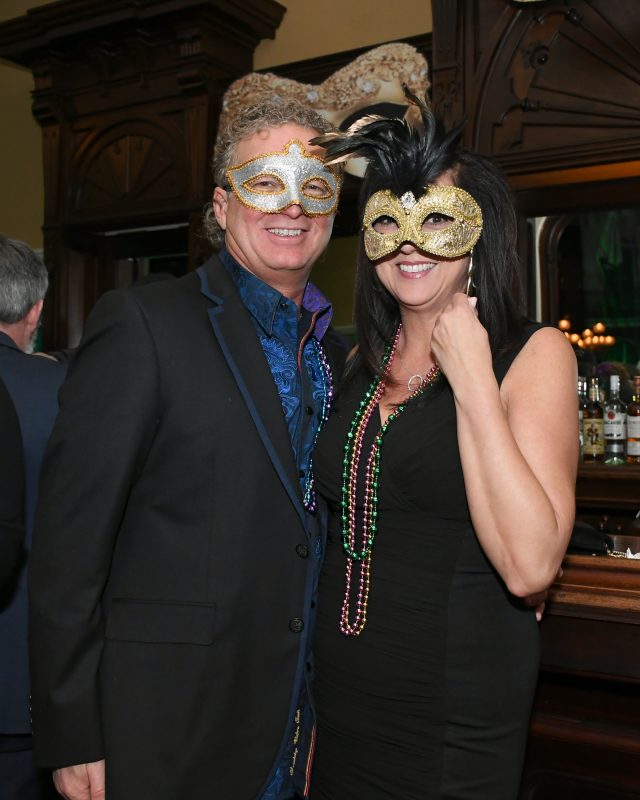 Couple with silver and gold masks on at Mardi Gras for AIM Services