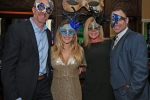 Group of four people with mardi gras masks on smiling at Mardi Gras for AIM Services