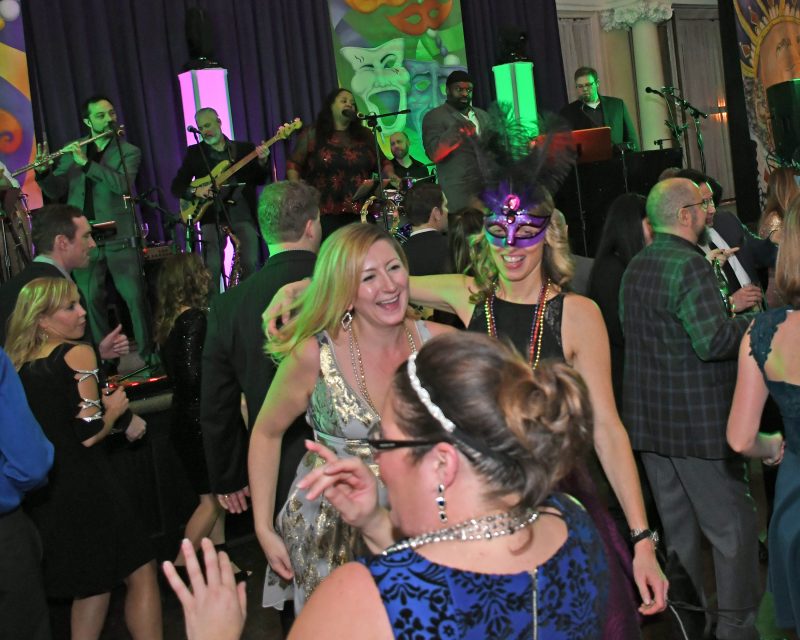 People dancing at Mardi Gras event for AIM Services