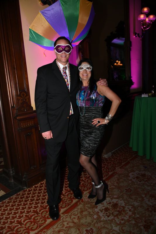 Couple in masks at Mardi Gras event for AIM Services