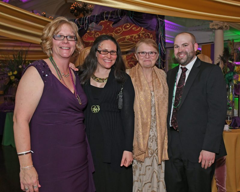 Group of four people at Mardi Gras event for AIM Services