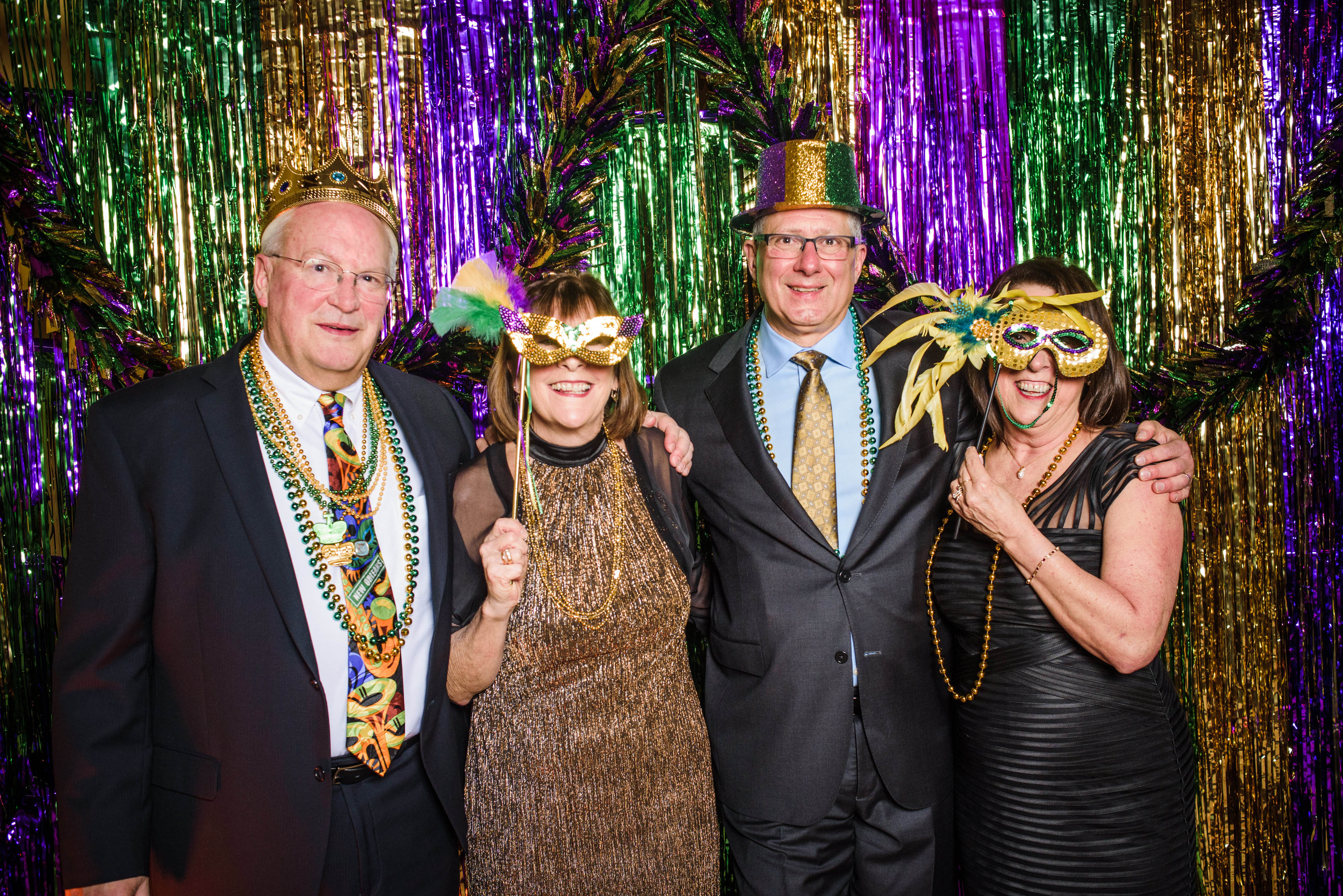 Two couples posing for photo at Mardi Gras event