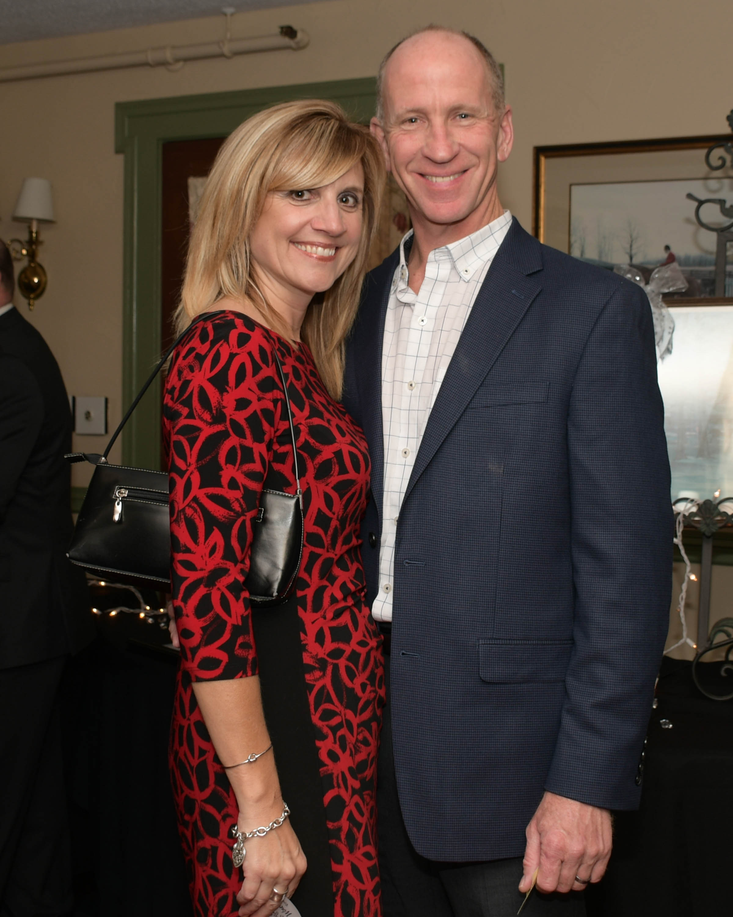 Vin Le Soir to benefit AIM Services, Inc. couple at event in suit and red dress