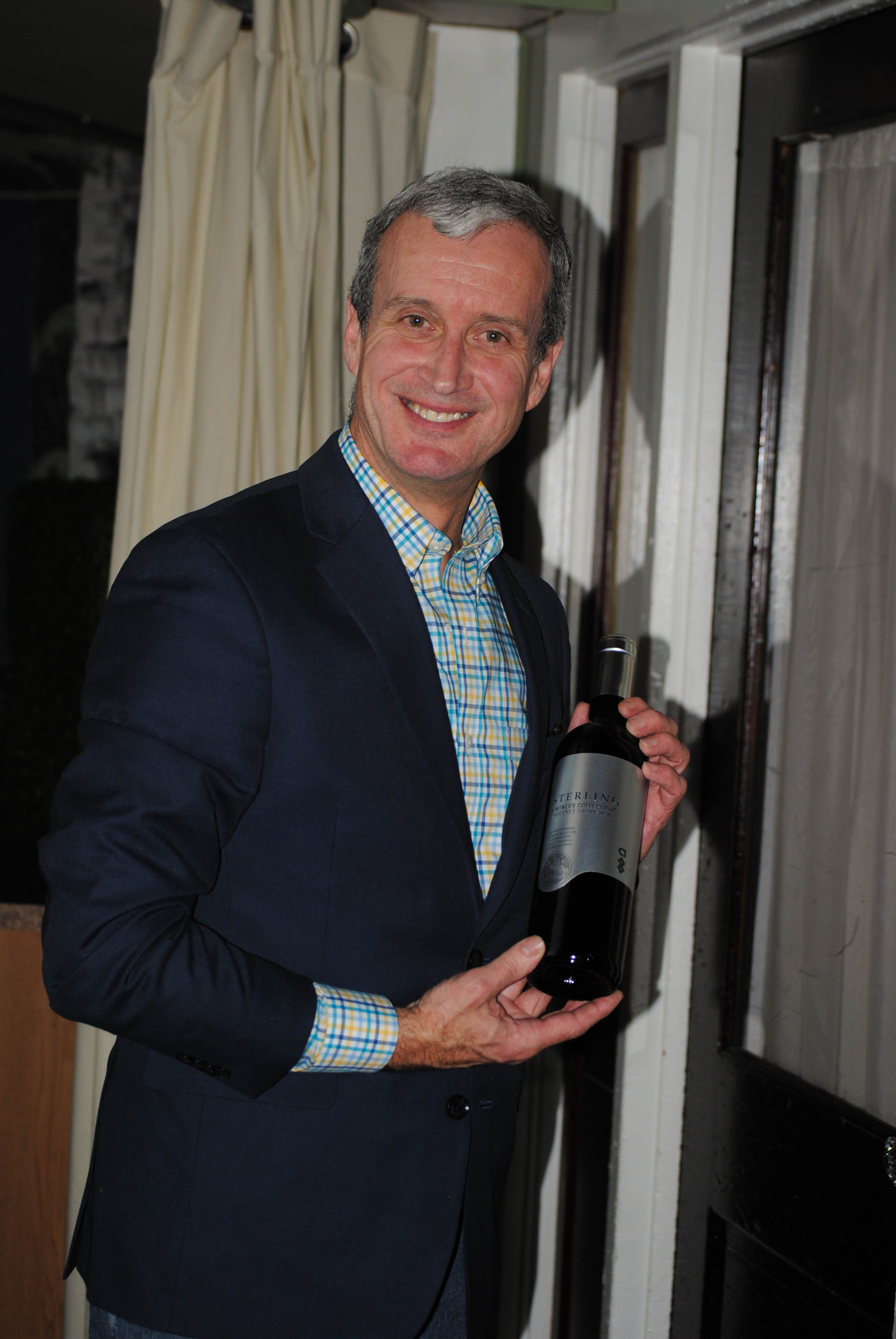 Vin Le Soir to benefit AIM Services, Inc. man holding bottle of wine