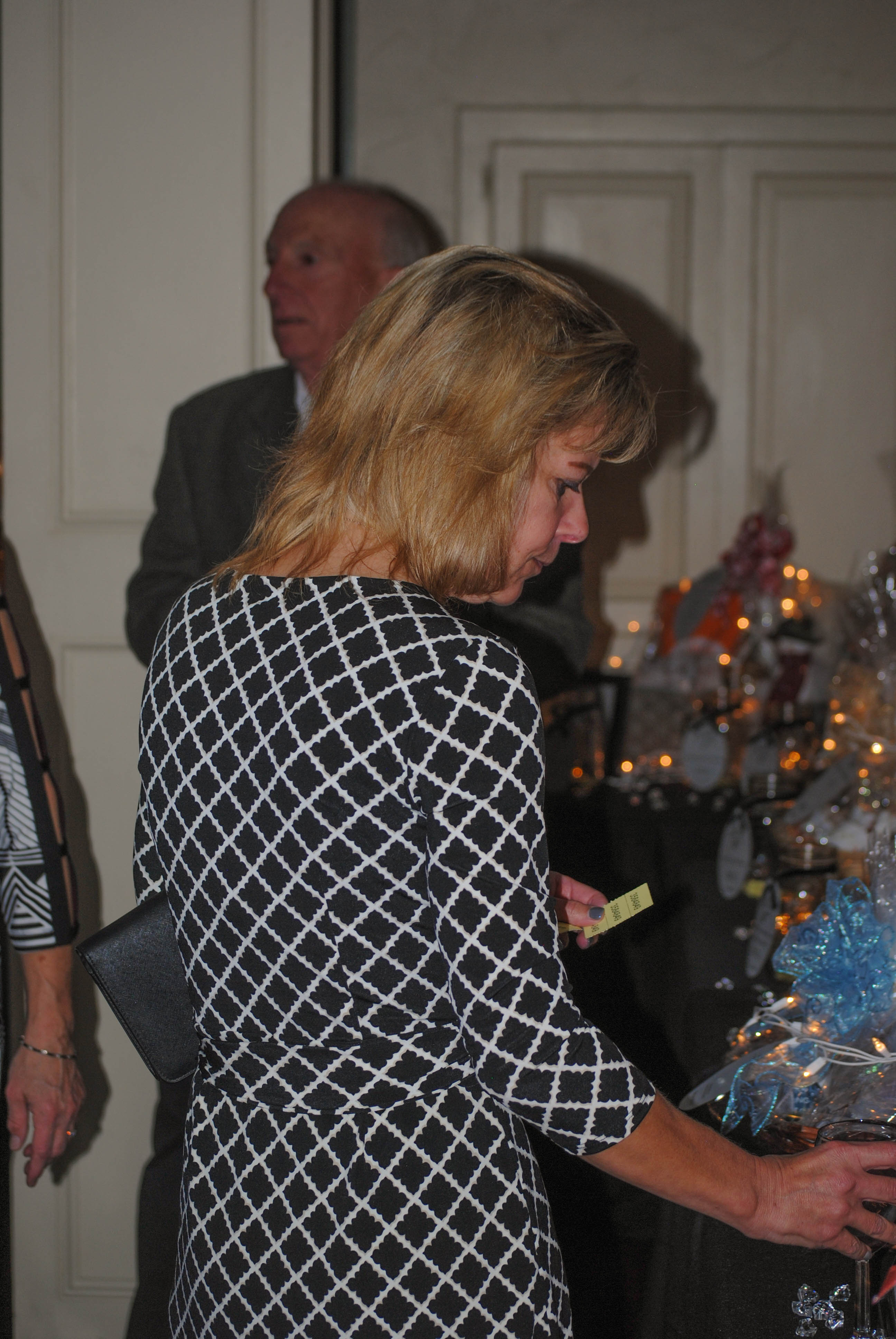 Vin Le Soir to benefit AIM Services, Inc. woman looking at raffle items