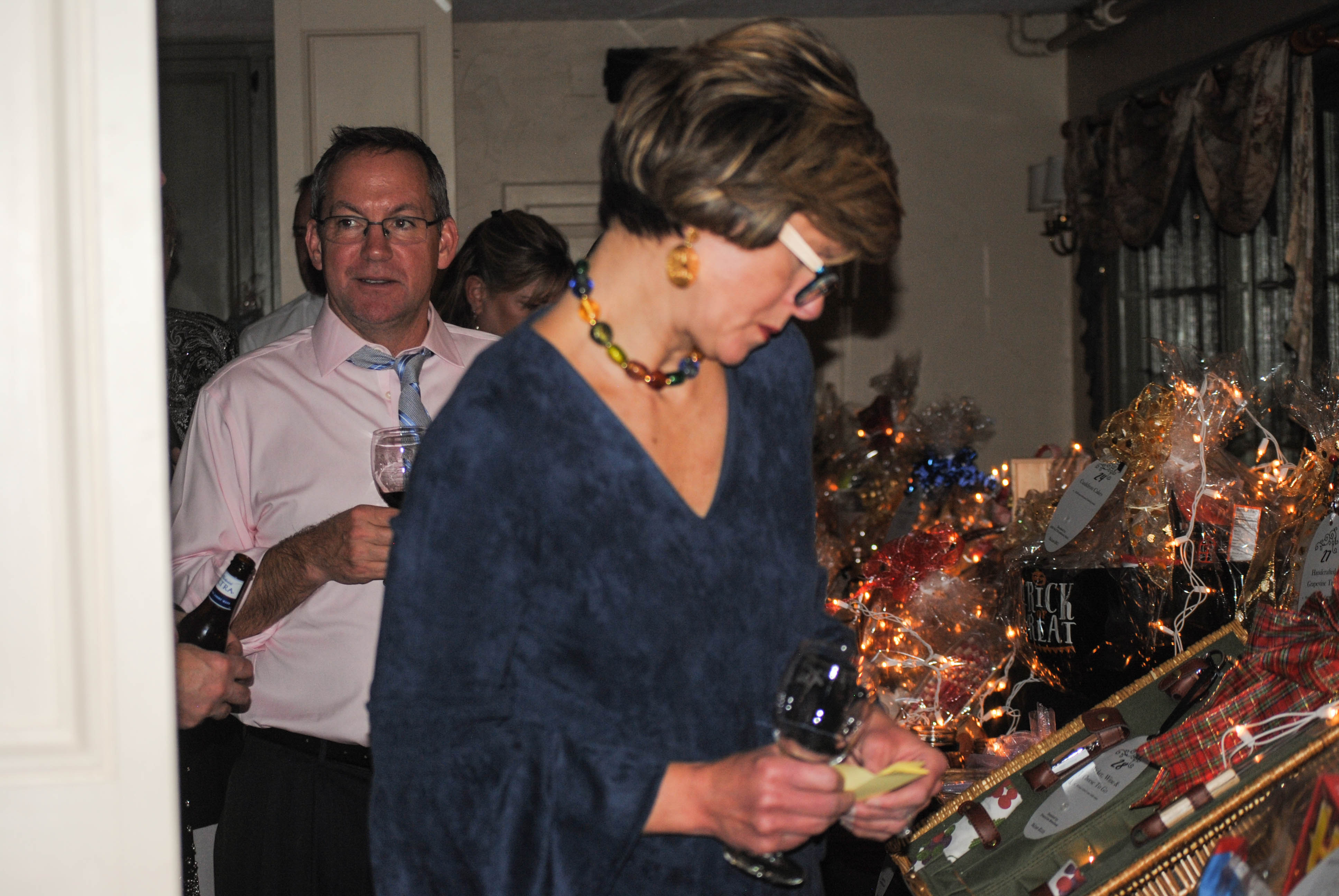 Vin Le Soir to benefit AIM Services, Inc. woman looking at raffle baskets