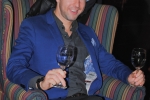 Vin Le Soir to benefit AIM Services, Inc. man sitting in lounge chair with two Vin Le Soir wine glasses