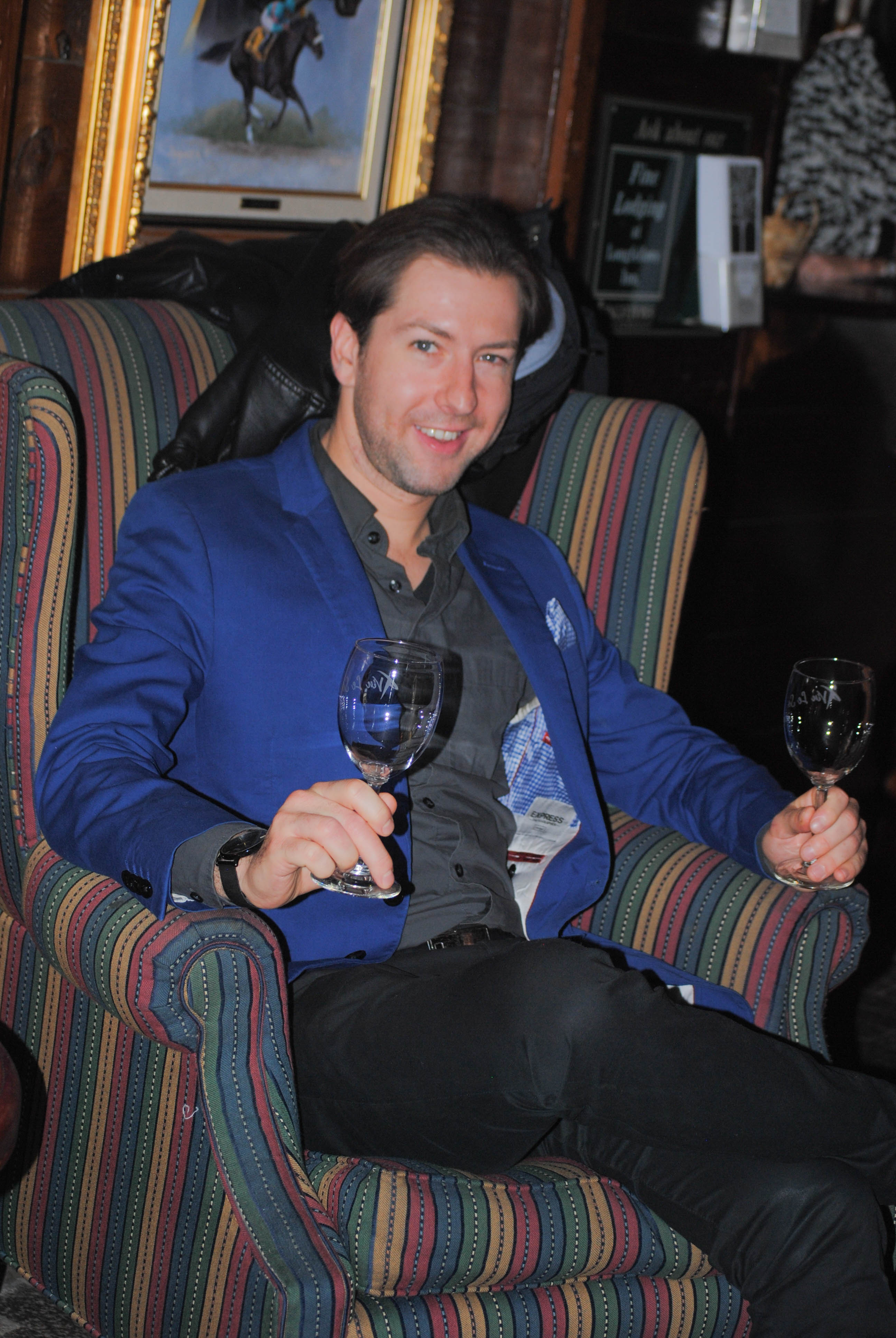 Vin Le Soir to benefit AIM Services, Inc. man sitting in lounge chair with two Vin Le Soir wine glasses