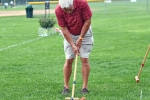 Man taking a shot at AIM Services Croquet on the Green event
