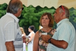 Group of three people talking under a tent with drinks at AIM Services Croquet on the Green event