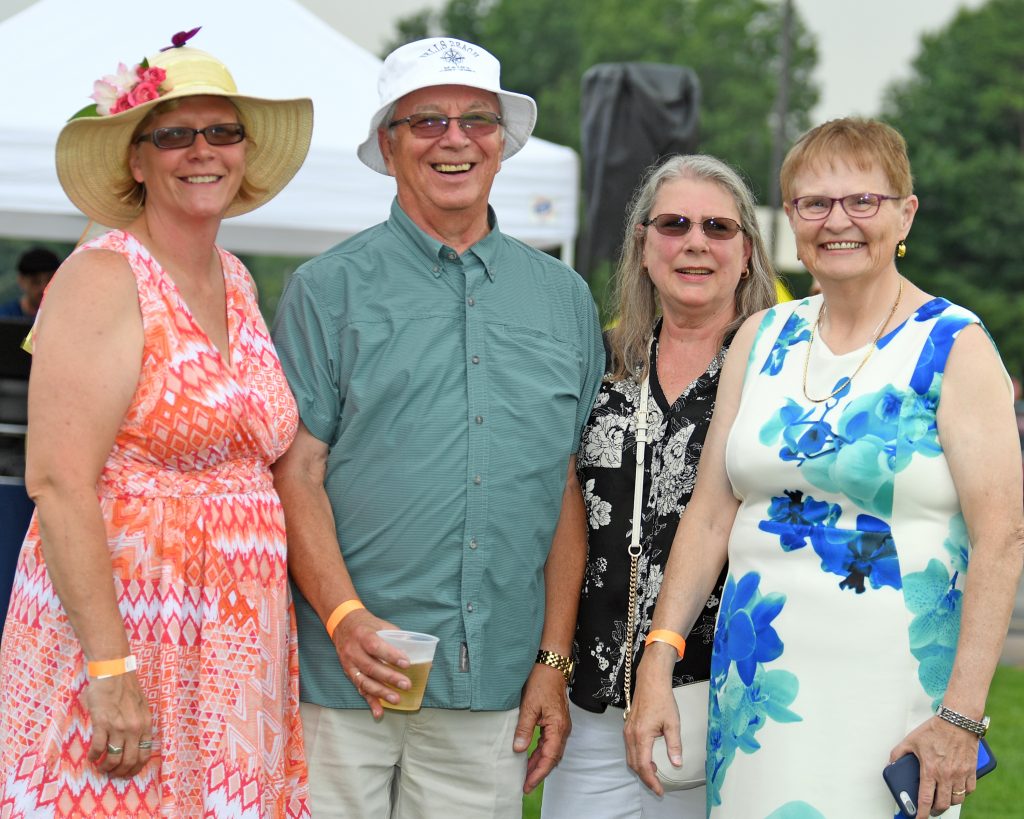 Group of four people smiling at the camera at AIM Services Croquet on the Green event