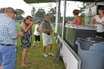 People getting food from deliciously different at AIM services Croquet on the Green event