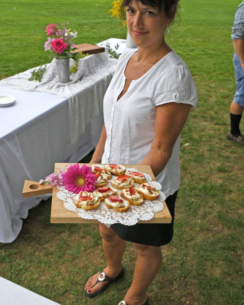 Server from deliciously different with food at AIM services Croquet on the Green event