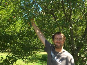 John holding an apple in a tree