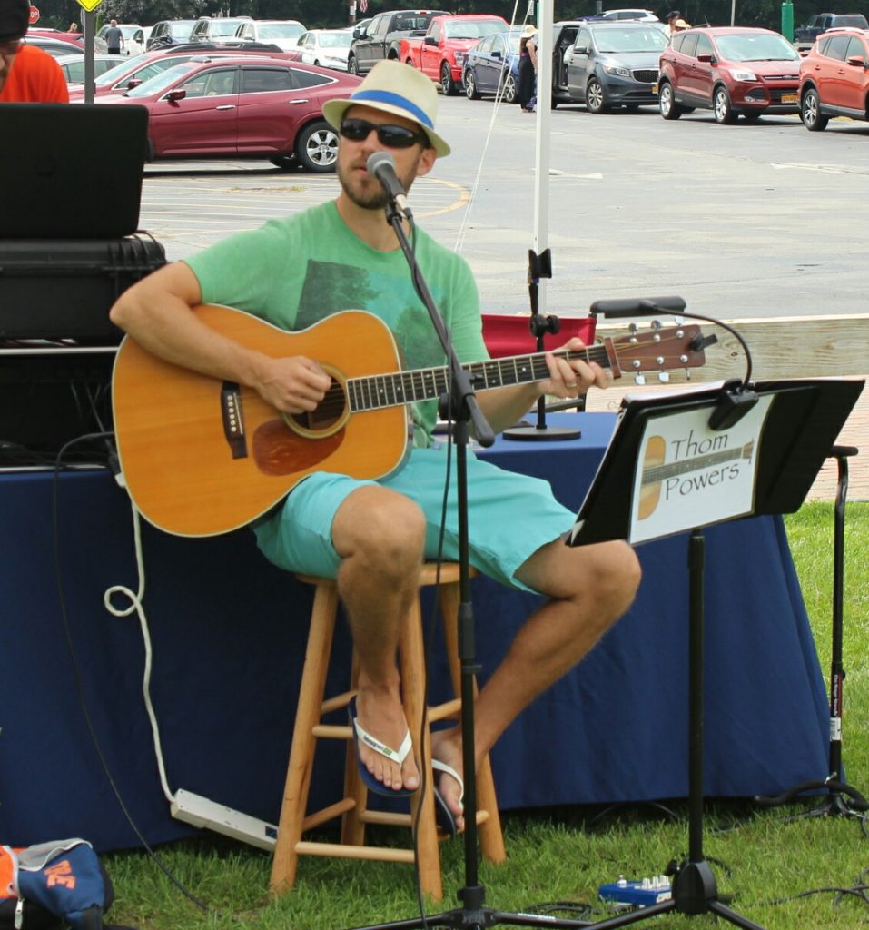 Thom powers playing guitar at AIM Services Croquet on the Green event