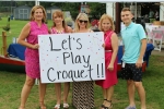 Group of people holding a sign that says let's play croquet!!