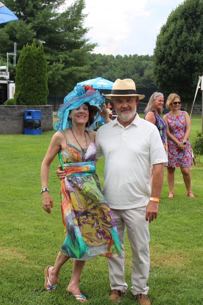 Couple dressed up pose for a picture at AIM Services Croquet on the Green event