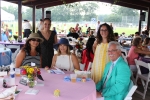 Group of people sitting at table with raffle tickets at AIM Services Croquet on the Green event