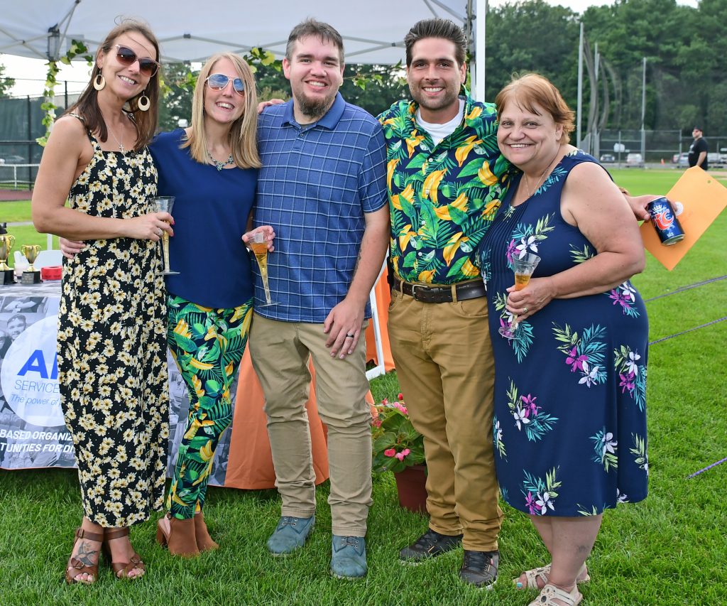 Group of give people smiling with glasses of sparkling wine at Croquet on the Green 2019