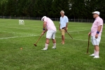 Man hitting croquet ball while two people watch at Croquet on the Green 2019