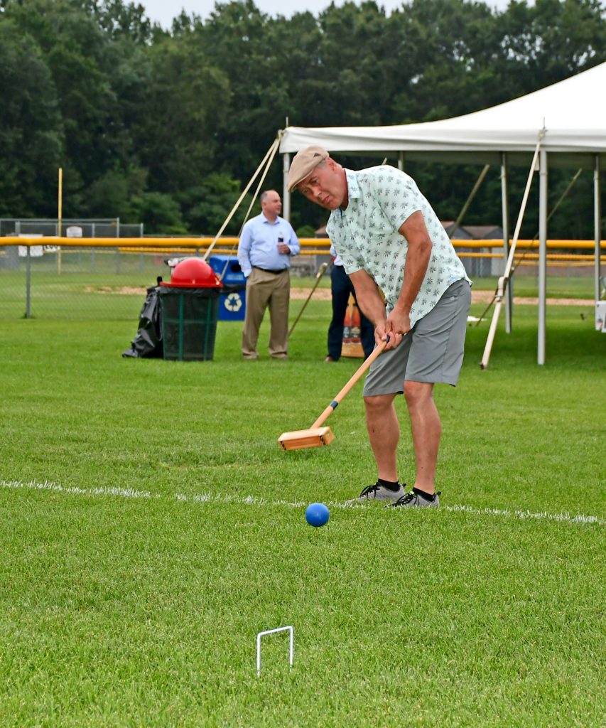 Man hitting croquet ball with mallet at Croquet on the Green 2019