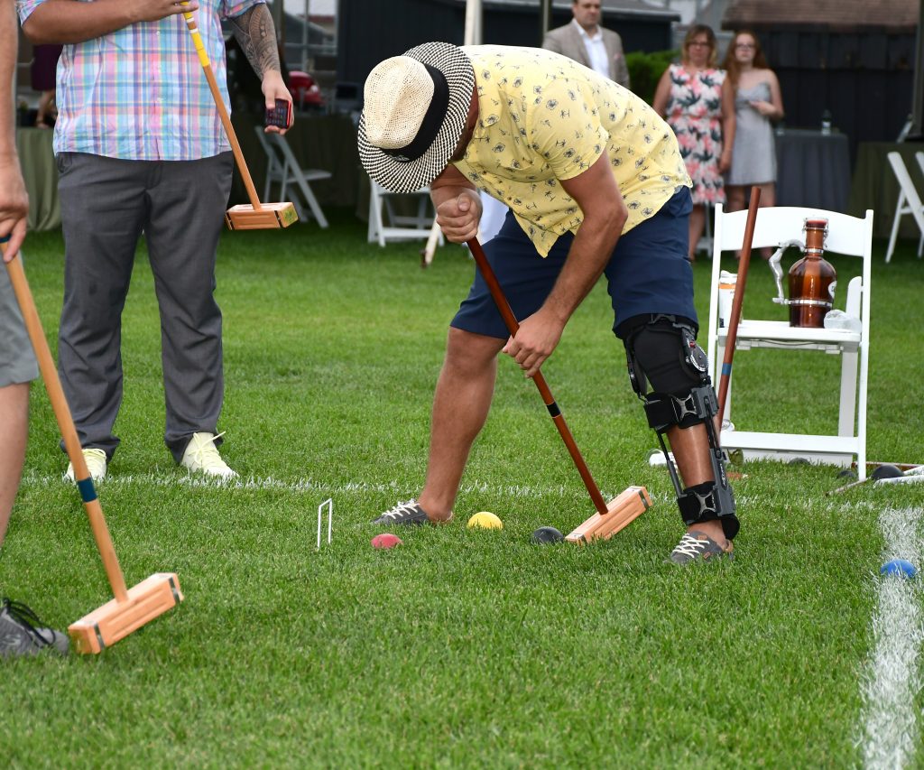 man bent over lining up a croquet shot at Croquet on the Green 2019