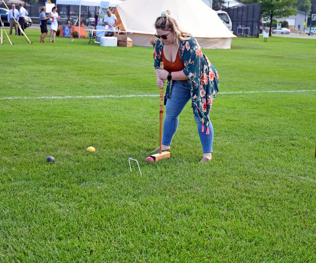 Woman bent over about to take a shot at Croquet on the Green 2019